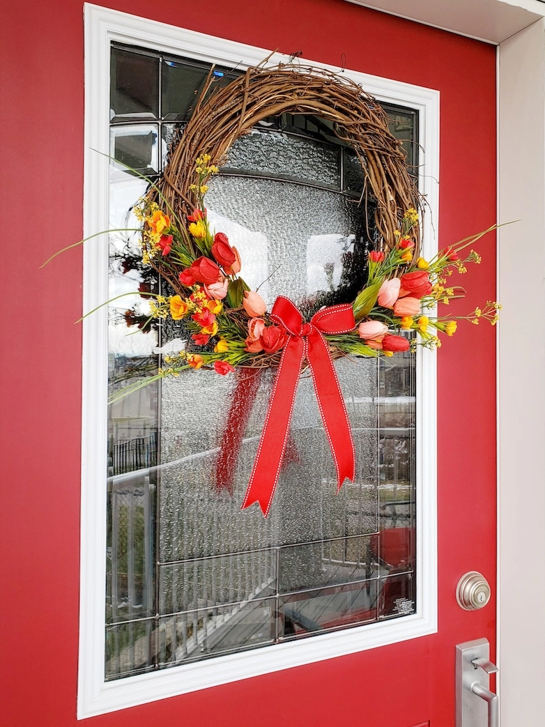 spring and summer wreath on a red front door