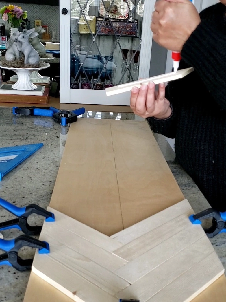 Using wood glue and clamps to bond wood pieces together