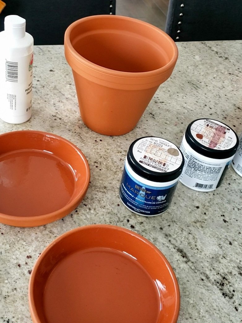 Raw terracotta pot and paint jars