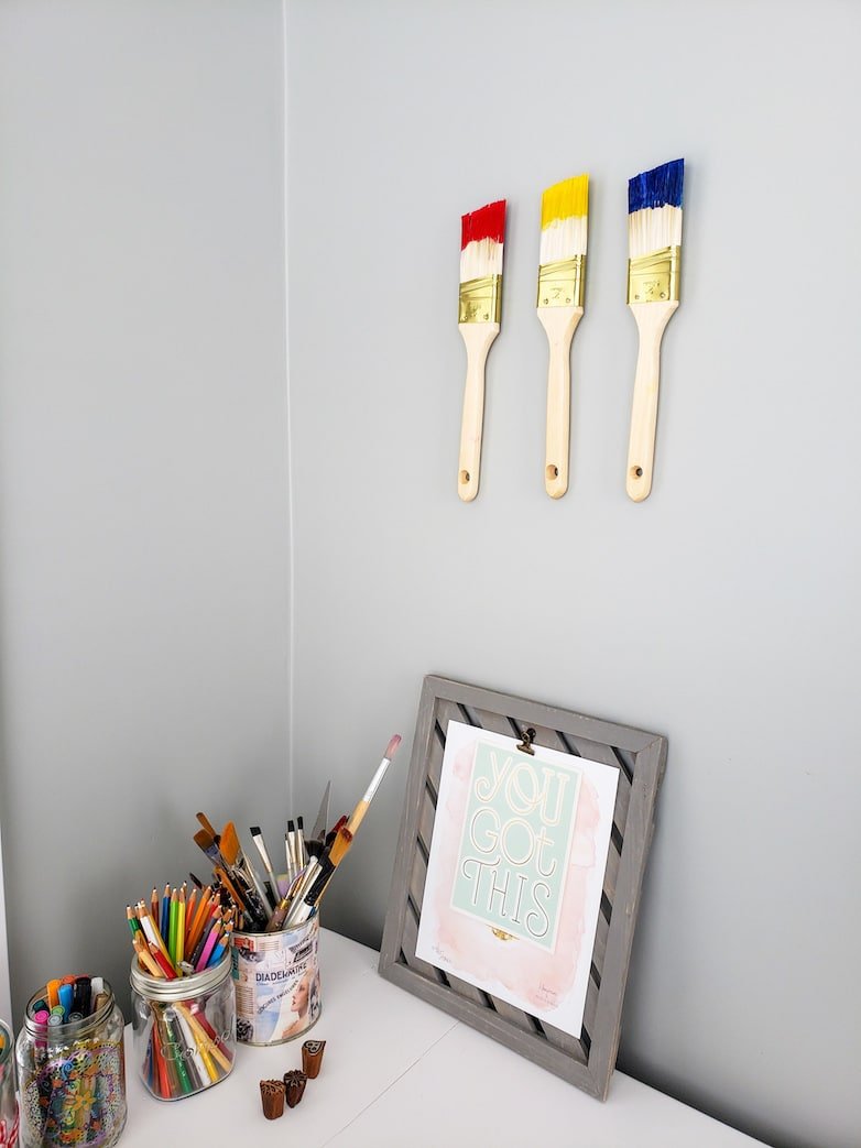 craft room wall decor: 3 paint brushes dipped in primary colours