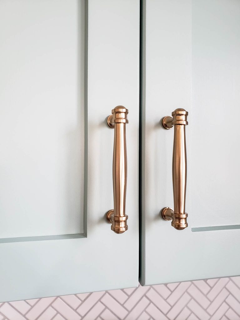 Champagne bronze hardware on painted kitchen cabinets