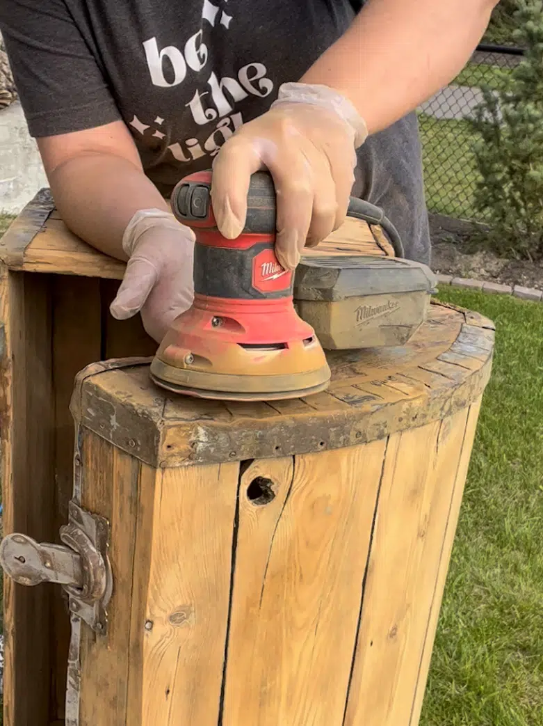 Sanding a vintage trunk to prep for a makeover