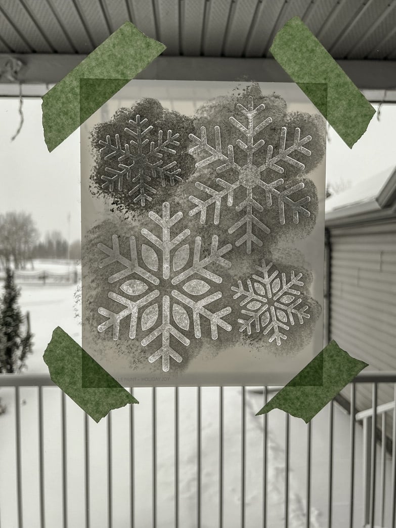 Stencilling snowflakes on a window