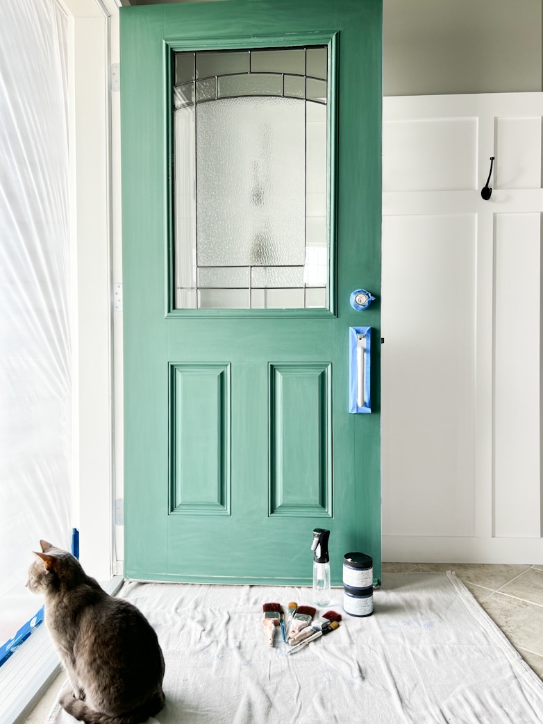 Green front door is prepared to be painted. 