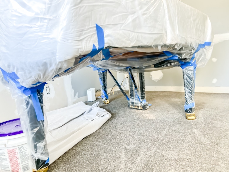 Grand piano wrapped up in plastic to protect from dust and paint