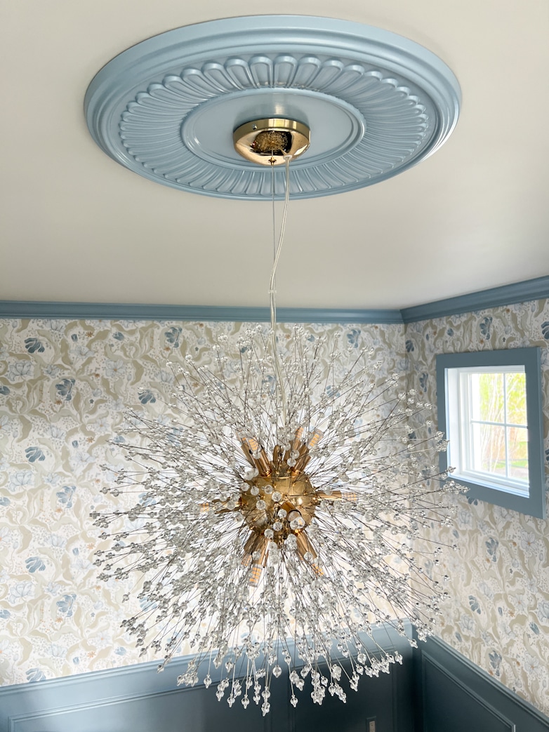 Newly installed chandelier with a blue ceiling medallion