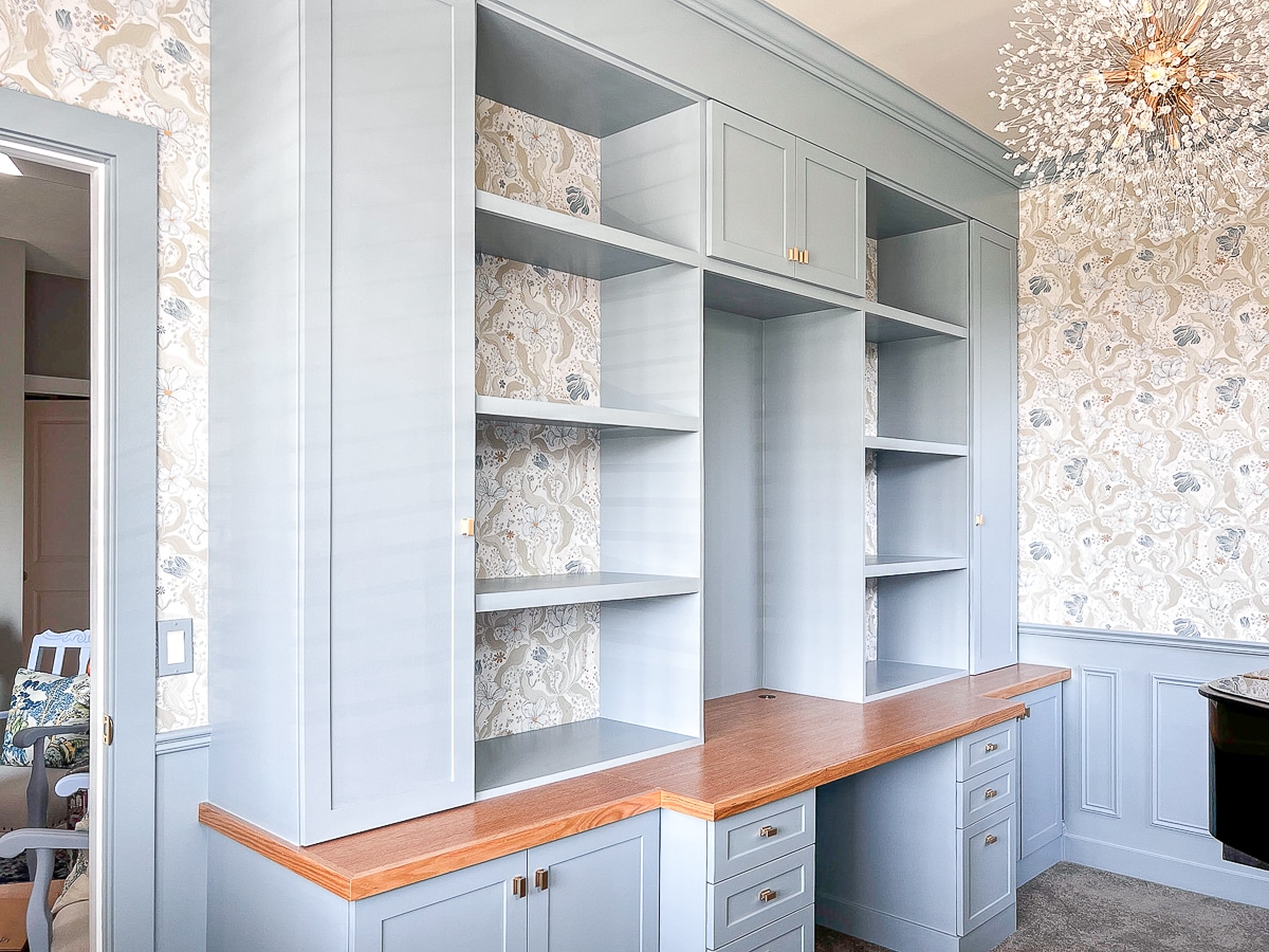 Home office built-ins with storage cabinets, bookcases and a desk area