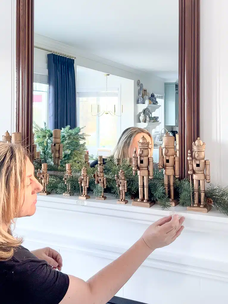 Adding clear hooks to a mantel to hang green garland on.