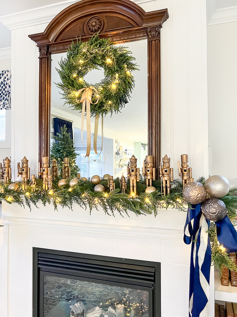 A mantel decorated for Christmas with gold nutcrackers and green garlands