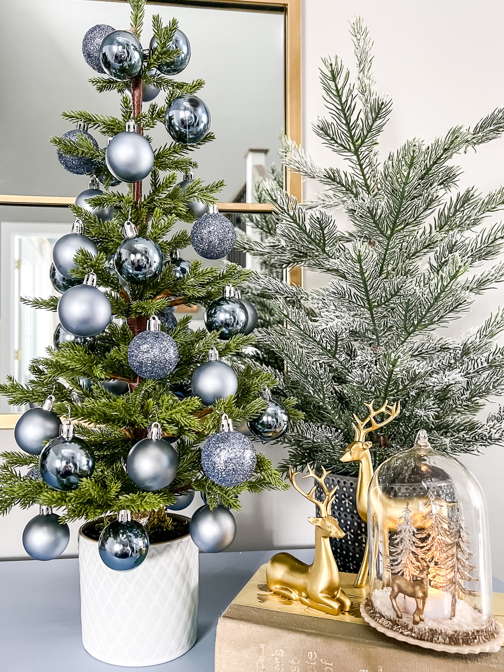 All blue ornaments decorate a mini tree on a blue console table in the entryway.