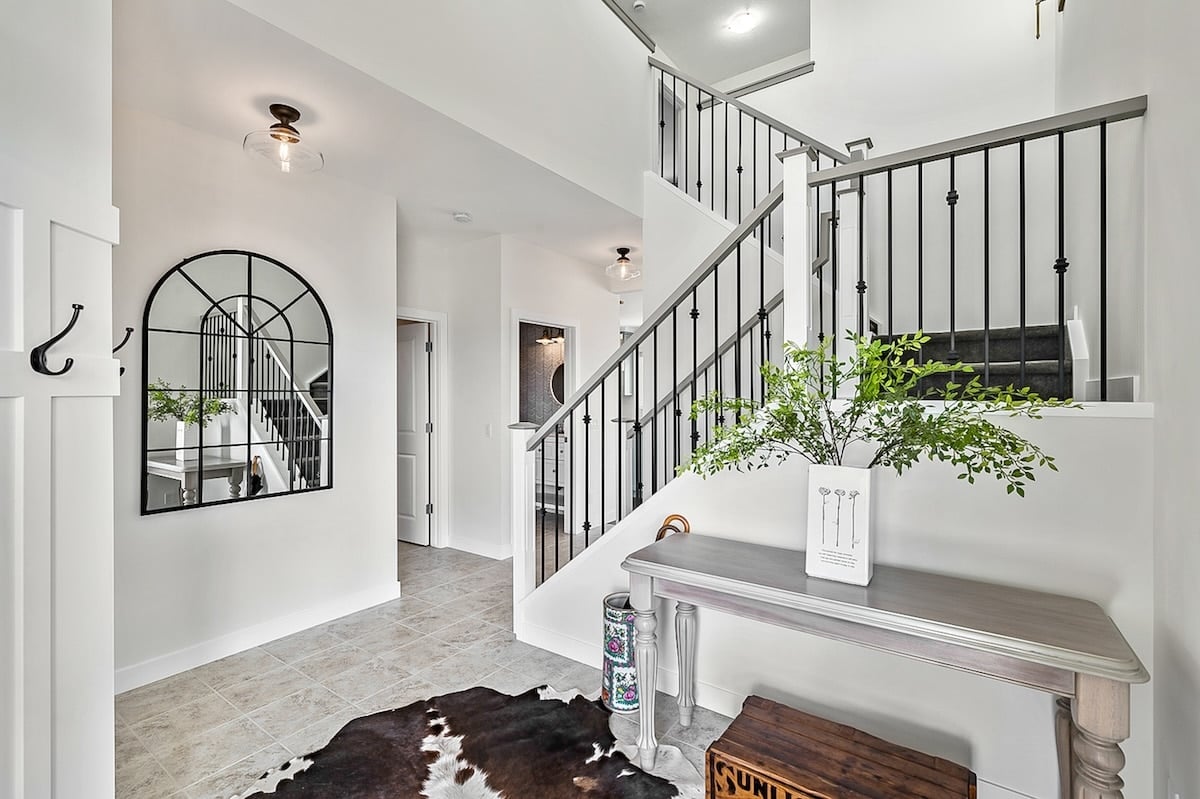 The entryway with a console table, huge mirror and a view of the staircase.