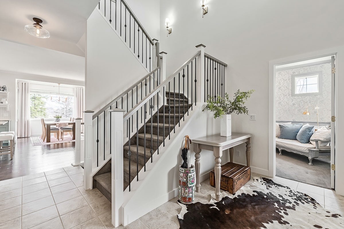 A view of the staircase with the main living area to the left and the home office to the right.