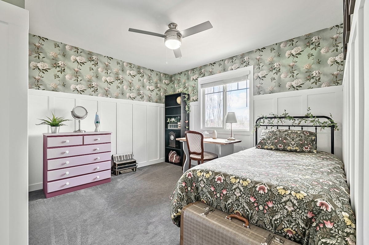 A bedroom with a bed and dresser