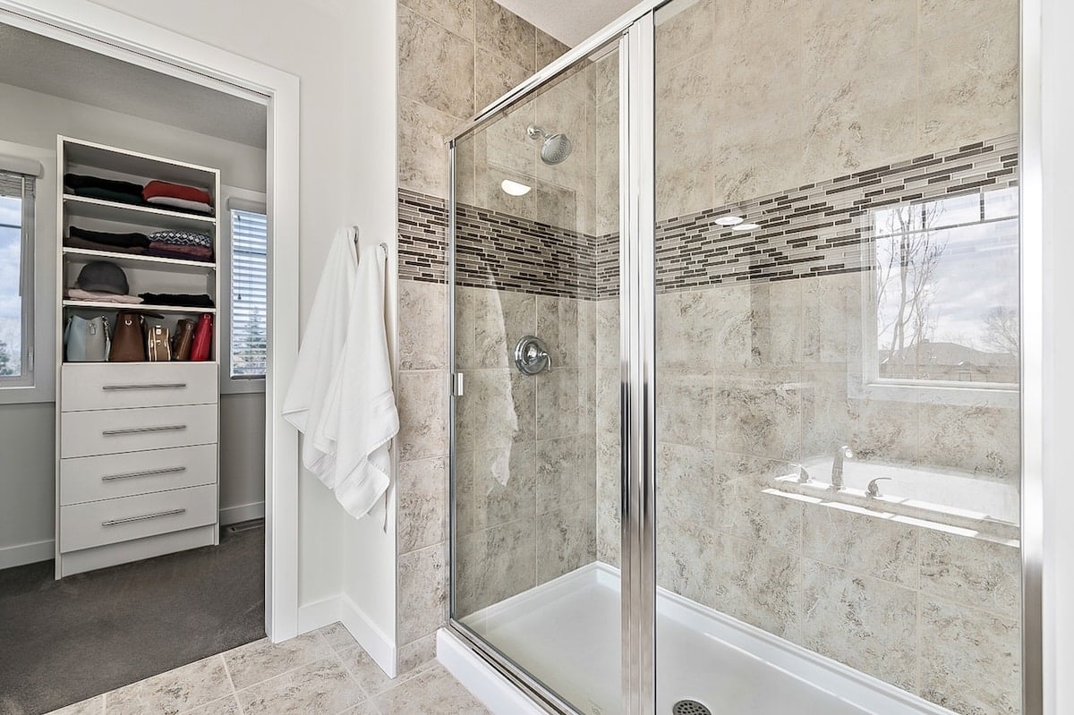 A shower with glass doors and a bathtub
