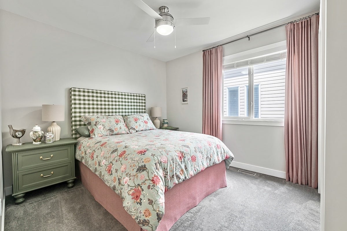 A bedroom with a bed and pink curtains